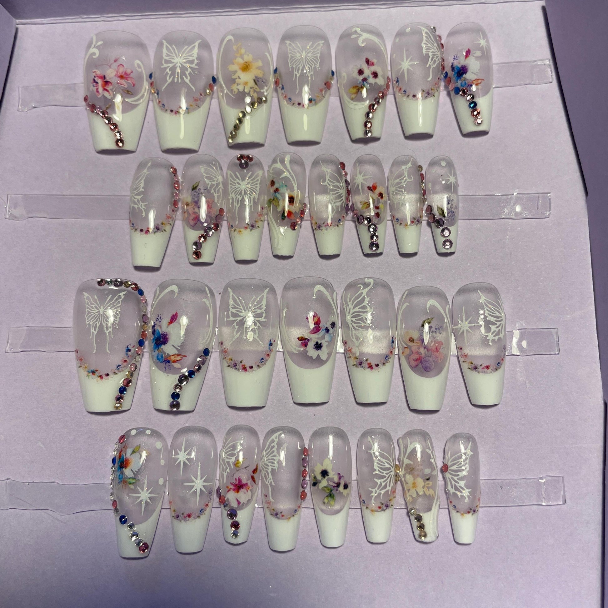 Kit 28 pièces. French blanche avec motifs fleurs et papillons. Tailles 0à 11. Réutilisables, Press-on nails, faux ongles. Fini brillant