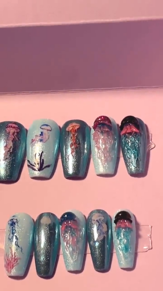 Kit complet. Toutes tailles incluses. Bleu métallisé avec petites méduses en relief. Réutilisables. Press-on nails, faux ongles. Fini brillant
