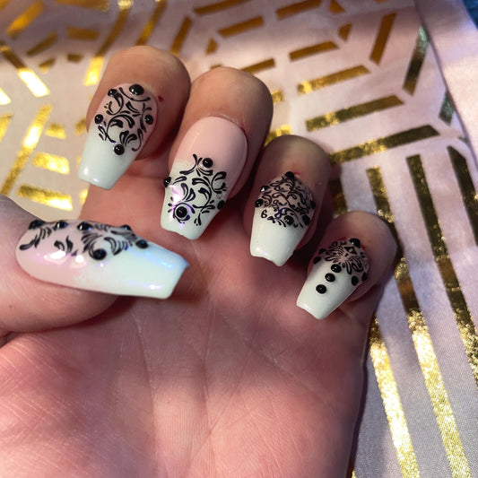 24 pièces. Rose et blanc avec motifs noirs. Tailles 0 à 11. Faux ongles, press on nails. Réutilisables. Finition brillante