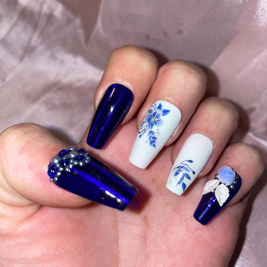 24 pièces. Fleurs bleues, et argent. Bleu jelly et blanc. Tailles 0 à 11. Réutilisables. Press-on nails, faux ongles. Finition brillante.