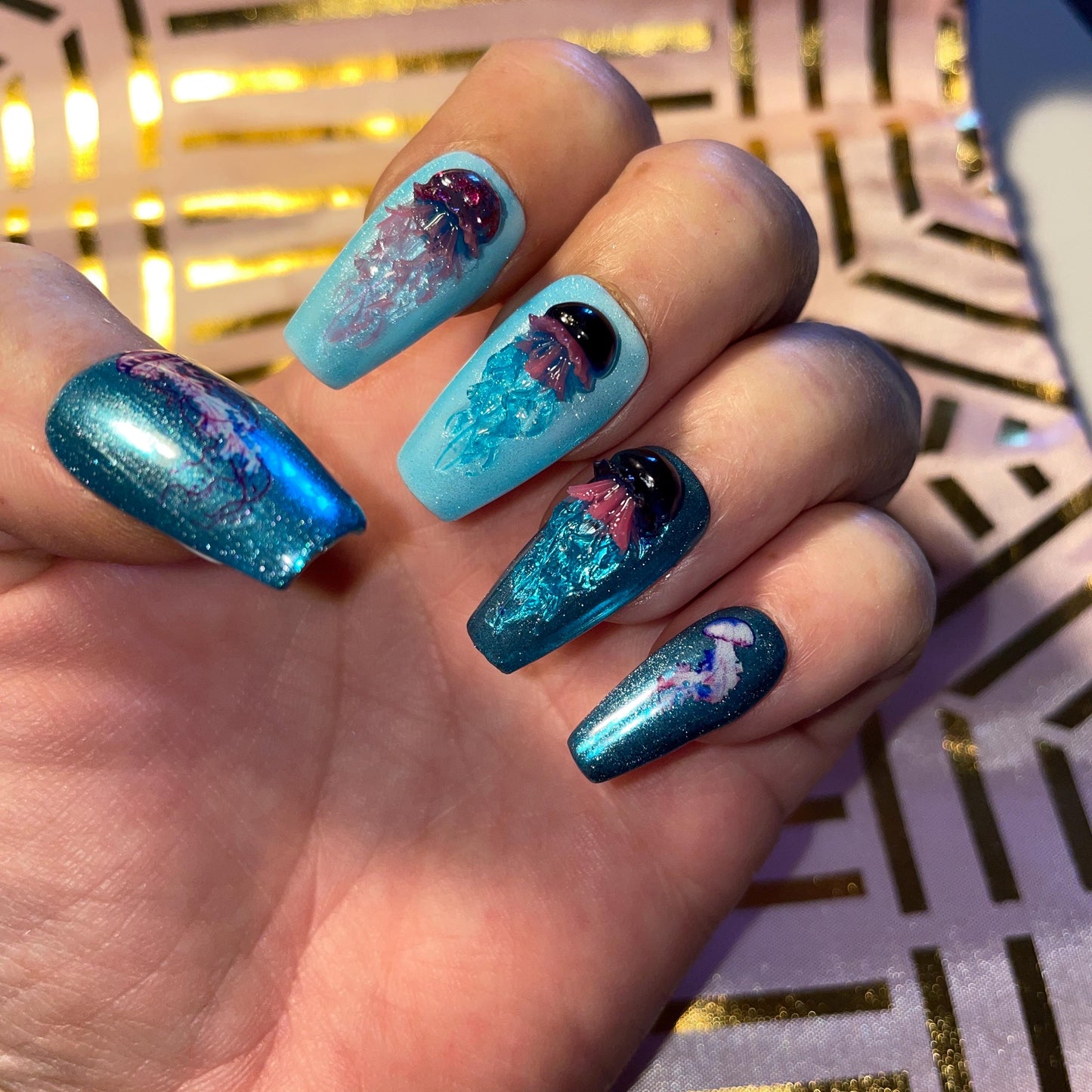 Kit complet. Toutes tailles incluses. Bleu métallisé avec petites méduses en relief. Réutilisables. Press-on nails, faux ongles. Fini brillant