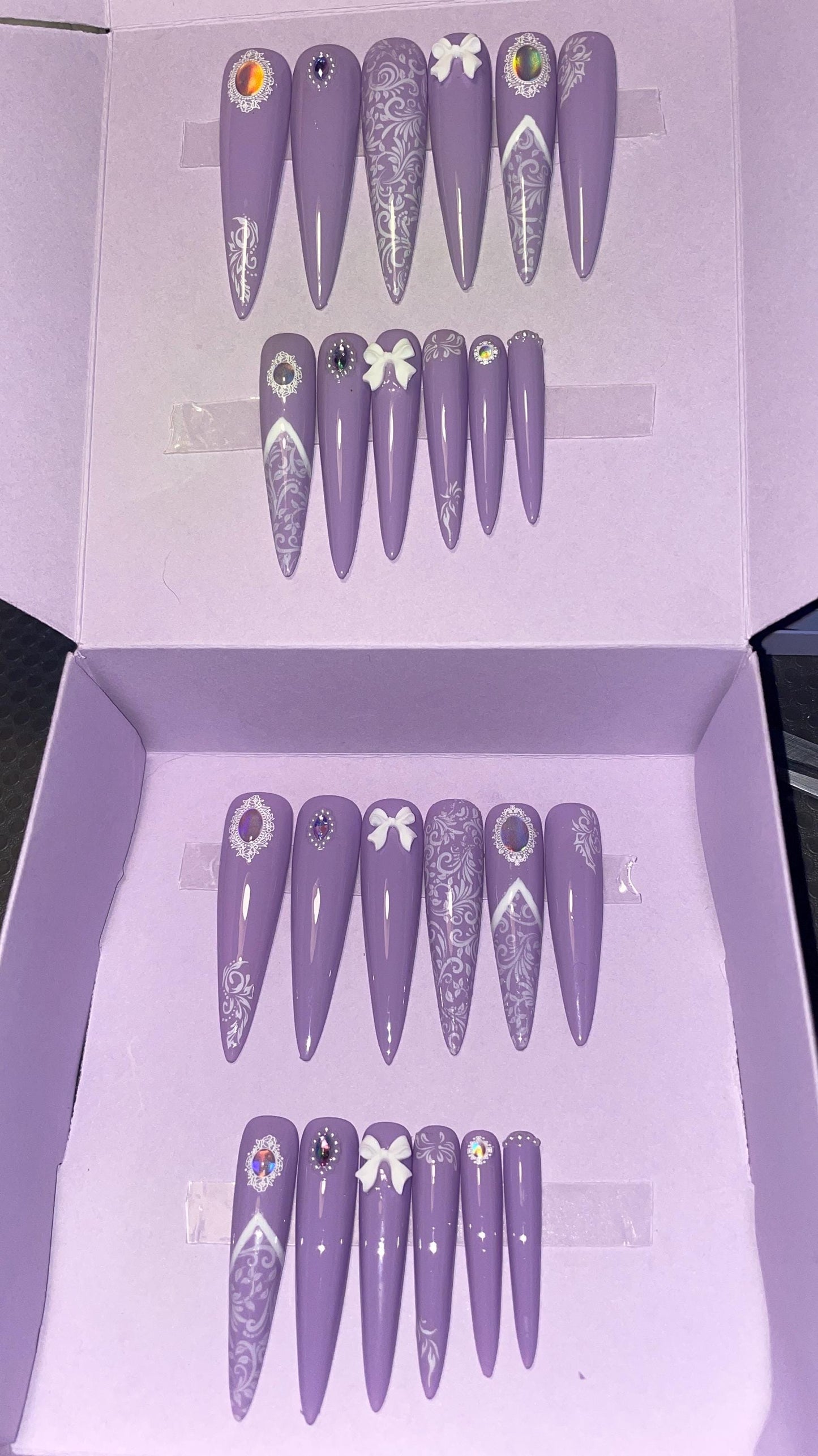 Dentelle blanche et violet avec petits noeuds et perles. Kit toutes tailles incluses. Réutilisables. Press-on nails, faux ongles. Finition brillante.