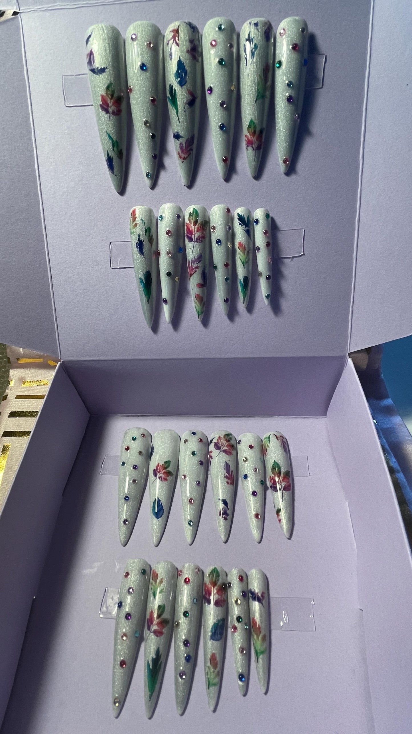Blanc avec feuilles et strass arc-en-ciel. Kit toutes tailles incluses. Réutilisable, Press-on nails, faux ongles. Finition brillante.