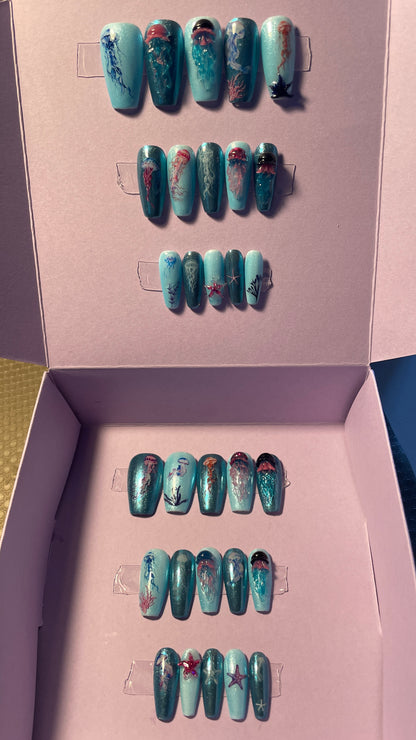 Kit complet. Toutes tailles incluses. Bleu métallisé avec petites méduses en relief. Réutilisables. Press-on nails, faux ongles. Fini brillant