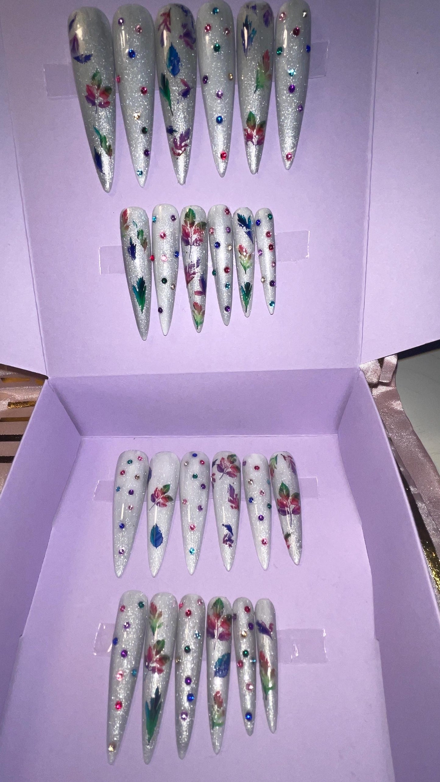 Blanc avec feuilles et strass arc-en-ciel. Kit toutes tailles incluses. Réutilisable, Press-on nails, faux ongles. Finition brillante.
