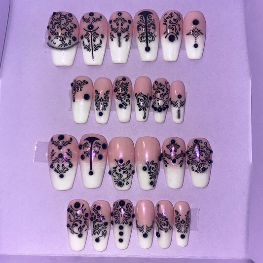 24 pièces. Rose et blanc avec motifs noirs. Tailles 0 à 11. Faux ongles, press on nails. Réutilisables. Finition brillante