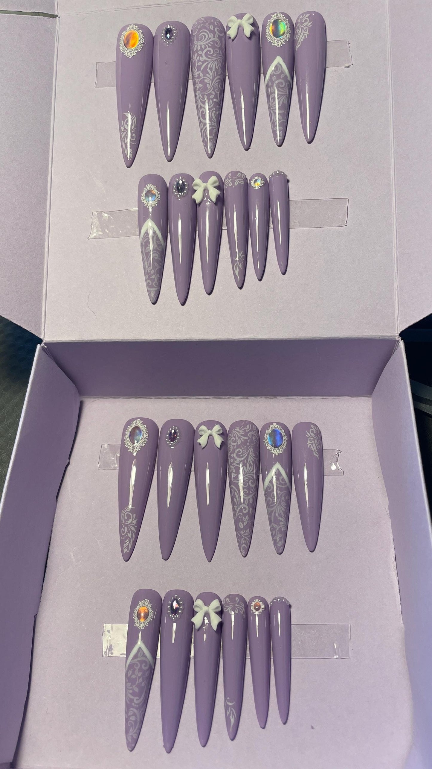 Dentelle blanche et violet avec petits noeuds et perles. Kit toutes tailles incluses. Réutilisables. Press-on nails, faux ongles. Finition brillante.
