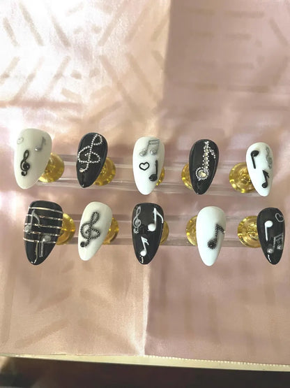 Quelques notes de musique, noir, blanc et argent. Réutilisable, Press-on nails, faux ongles. Finition brillante